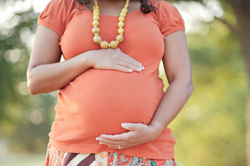 A pregnant woman holds her belly