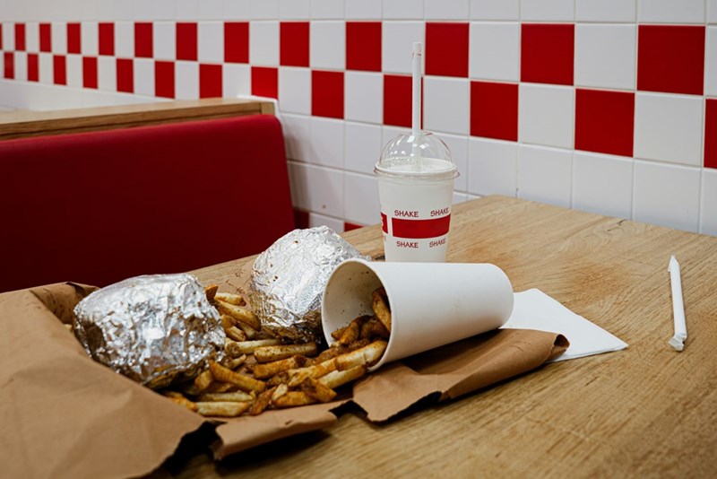 A burger and fries at a table in a fast food restaurant.