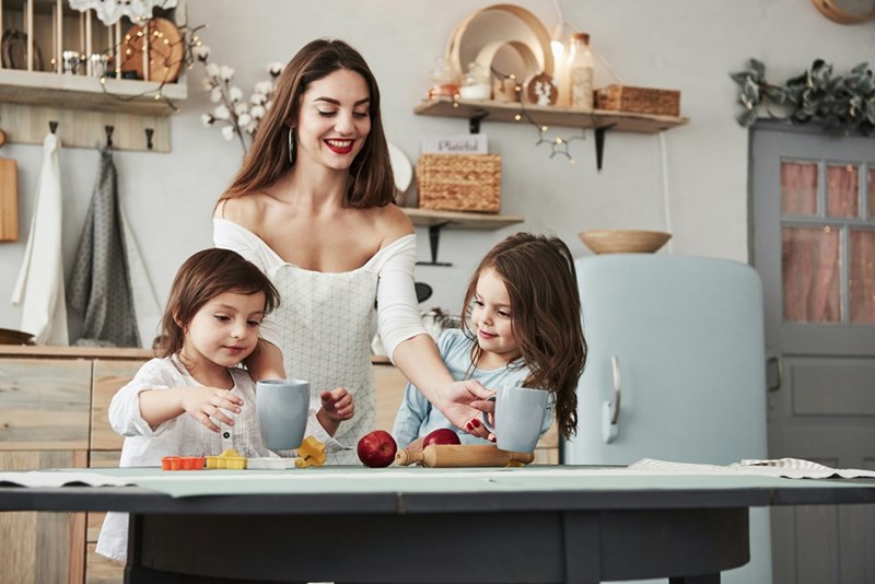 Smiling aunt cooks a meal with her nieces.