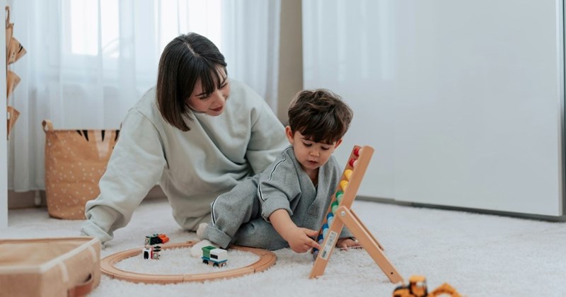 A woman plays games with her nephew while babysitting.