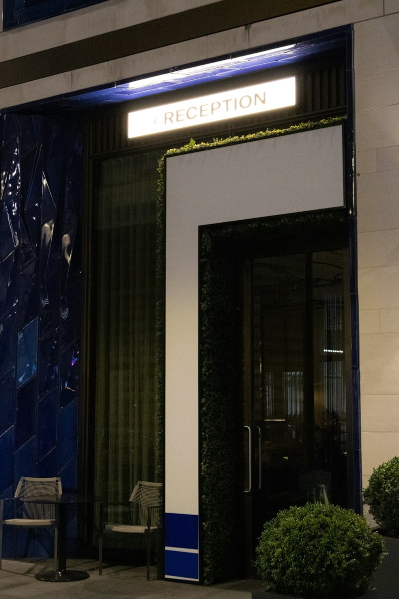 Modern hotel reception entrance at night with illuminated front desk signage