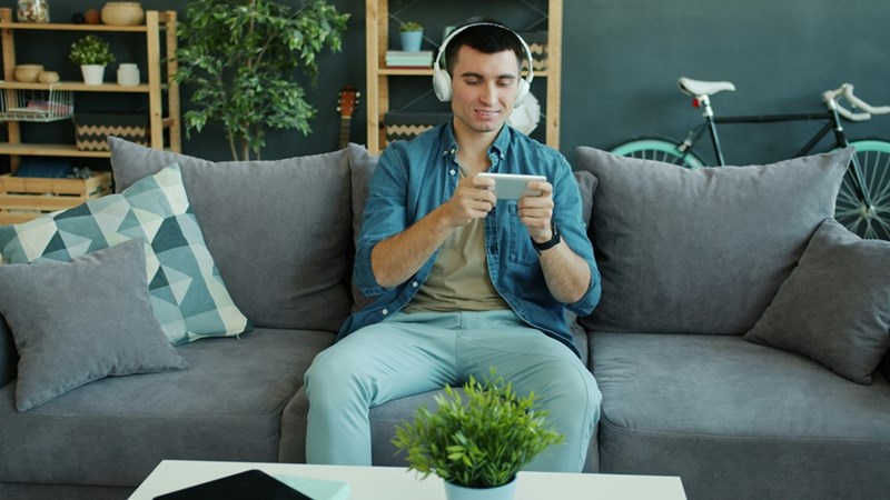 A man smiling while enjoying free internet access at home.