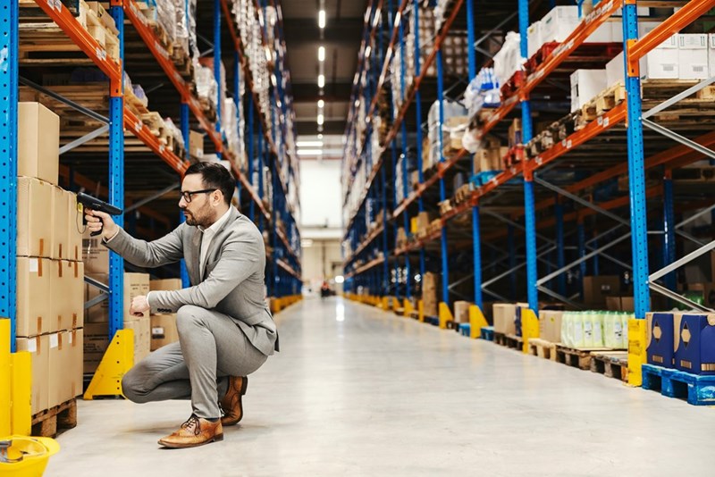 A supervisor checks boxes with a scanner in a warehouse.