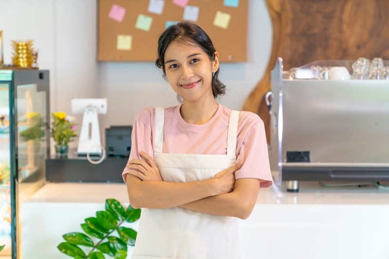 A female employee stands behind the counter of a breakfast establishment.