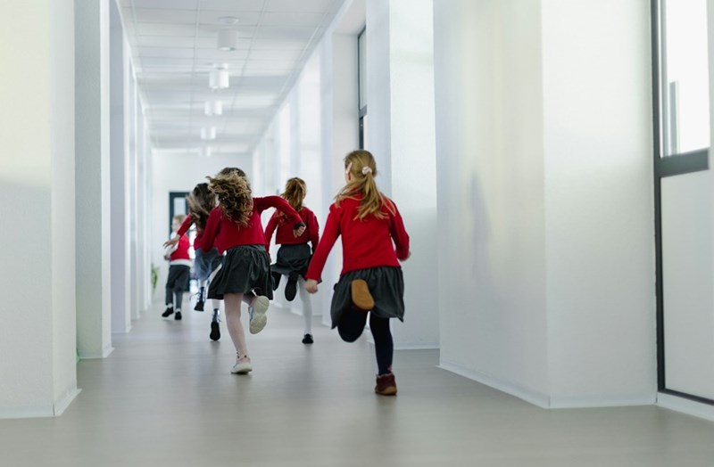 Children running through a private school hallway, capturing student life, education culture, and academic environments in modern schools.