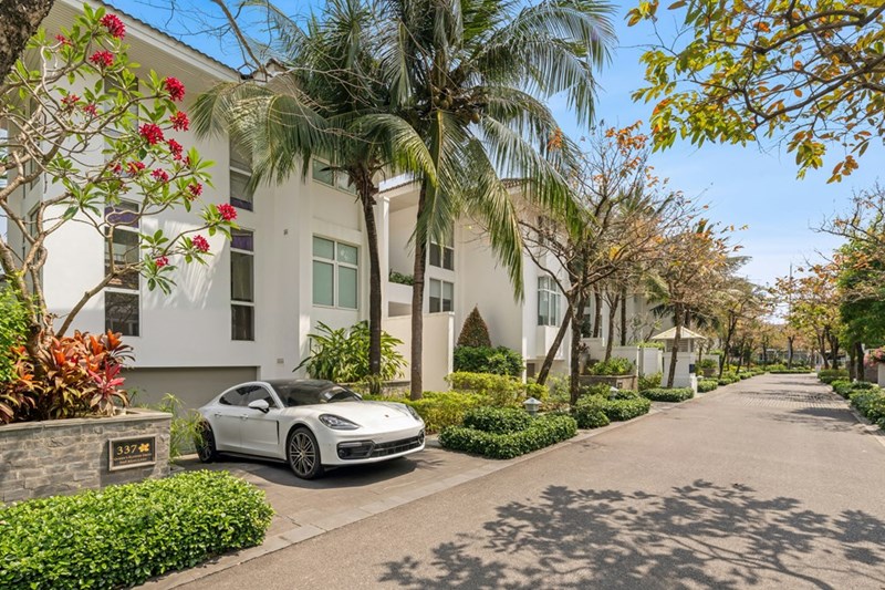 White car parked in the driveway of a luxurious home.