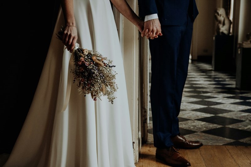 Man in suit holding woman in white dress