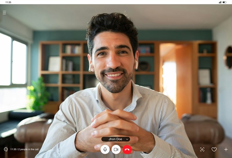 A screenshot of the young professional smiling while clasping his hands during his interview.