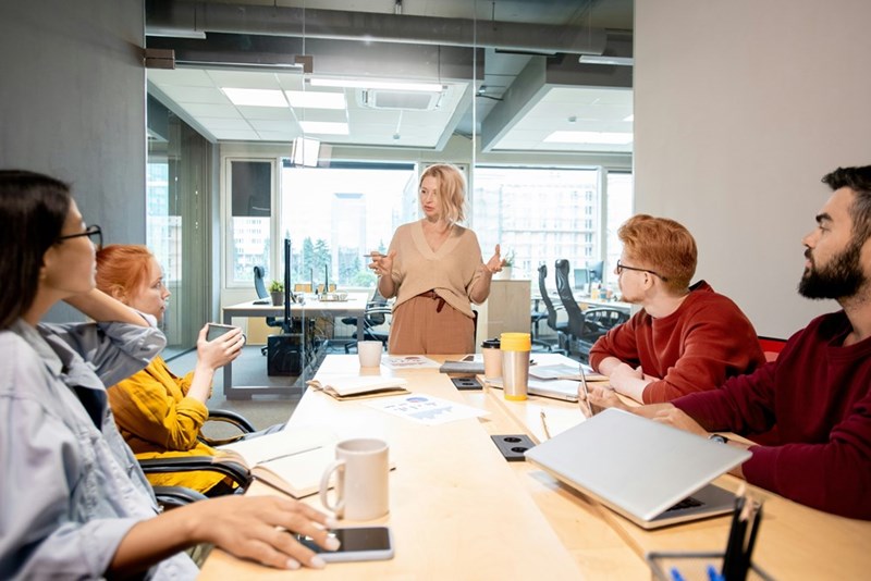 A woman talks to a conference room full of people