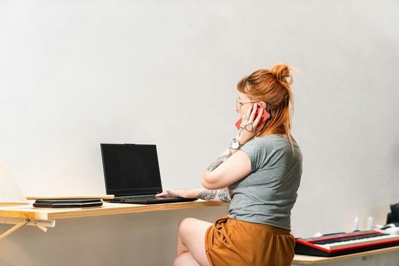 Woman takes a phone call in an open office.