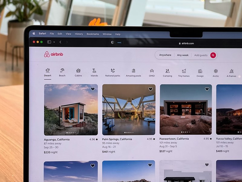 A person researches potential Airbnbs to rent.
