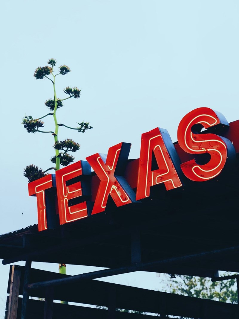 Bright Texas sign against a clear sky, symbolizing relocation to Texas, lower cost of living, and lifestyle changes in Austin.