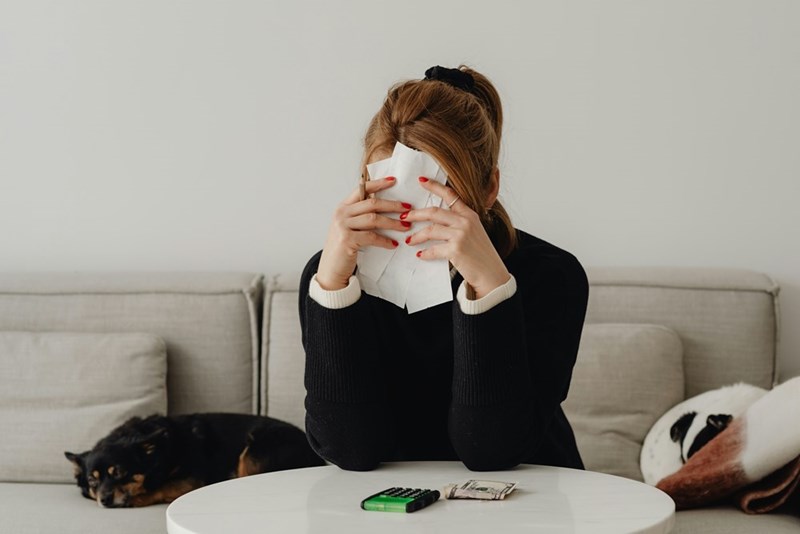 A woman looks frustrated sitting at the edge of the table