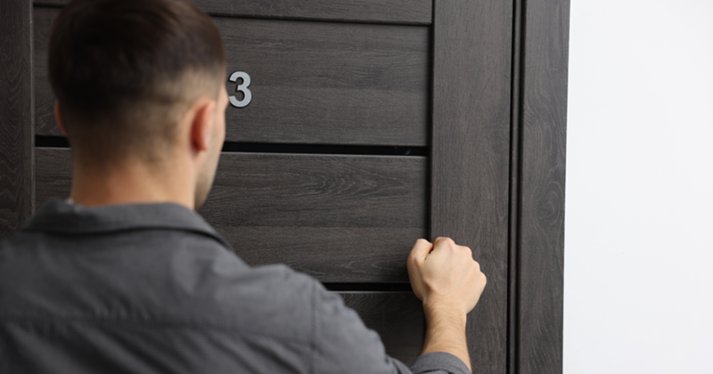 Man Knocking on Apartment Door