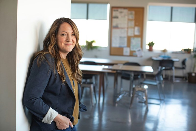 Smiling woman in business casual clothing standing in a bright modern office