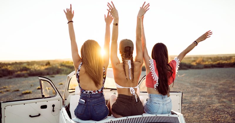 Young Women Driving on Road Trip