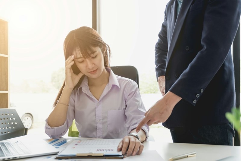 Overworked office employee dealing with micromanagement and pressure from management