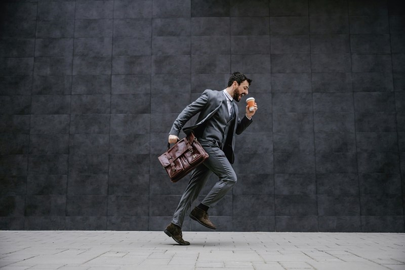 A young worker moves expressively on his way to work after being promoted.