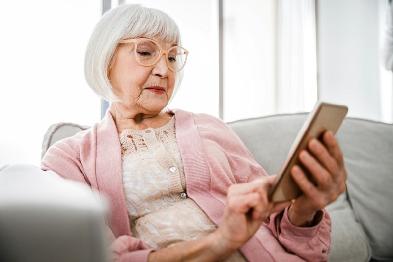 Elderly woman texting her neighbor, asking him to do home repairs for her.