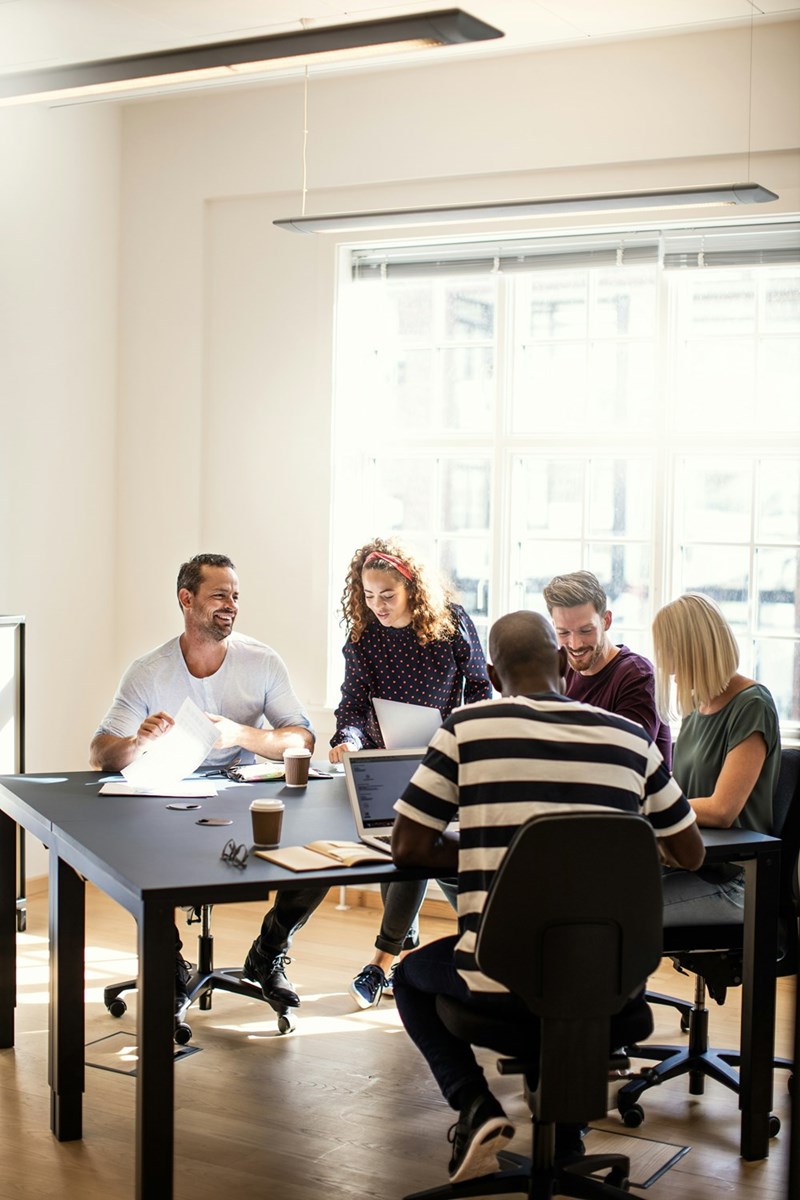 A group of employees meet in a professional meeting room