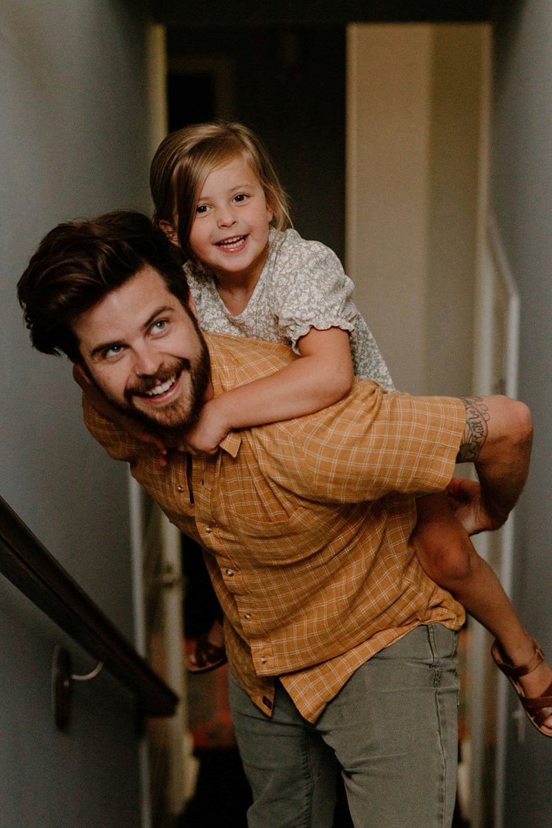 A man carrying a little girl up a flight of stairs