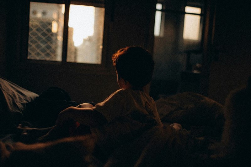 A baby waking up at dawn in bed.