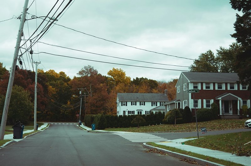 A small town in the suburbs filled with trees and a dead end street with houses.