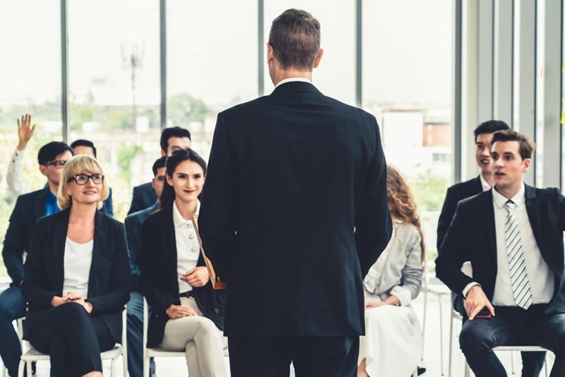 An entire company gathers in tense anticipation for what the boss has to say.