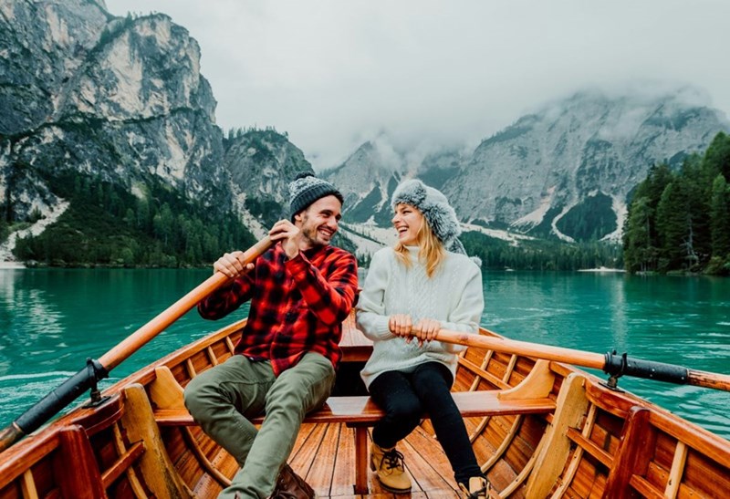 Romantic couple on a boat visiting an alpine lake at braise lake at braise Italy