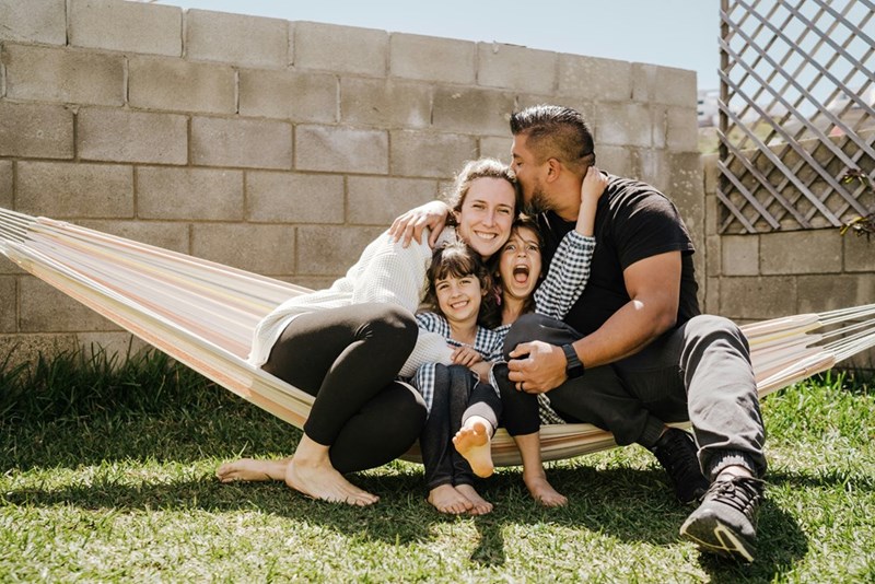 A family sitting in a hammock together