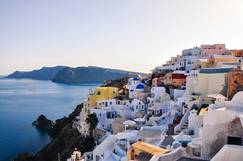 White and brown concrete houses near body of water during daytime