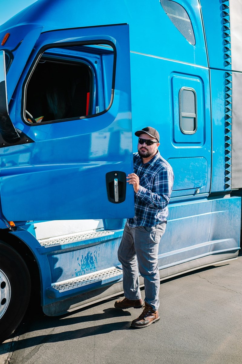 A blue-collar trucker gets into his sixteen-wheeler truck