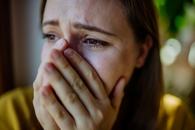 A woman suffering and crying at home
