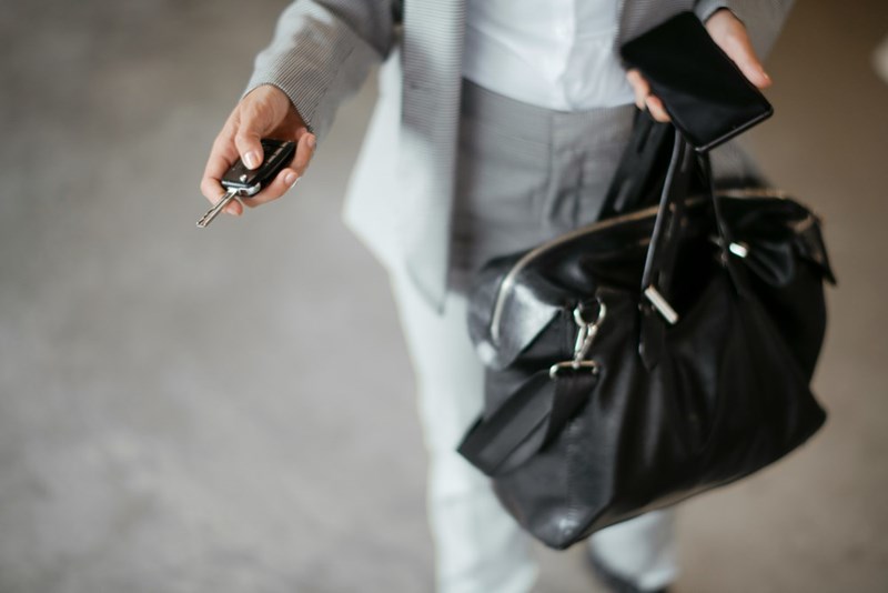 A businesswoman unlocks her car