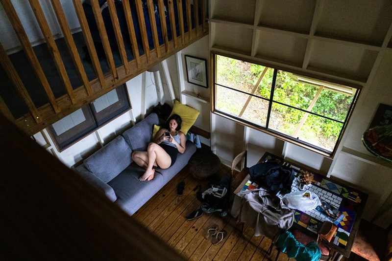 Woman relaxes on a couch inside a cozy cabin