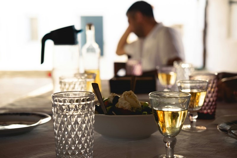 A man sits at a table with a glass of wine at a birthday dinner