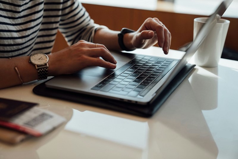 A remote worker uses their laptop at a table