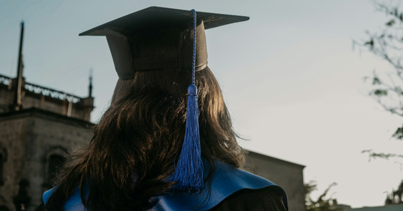The back of the head of a graduating college student outside