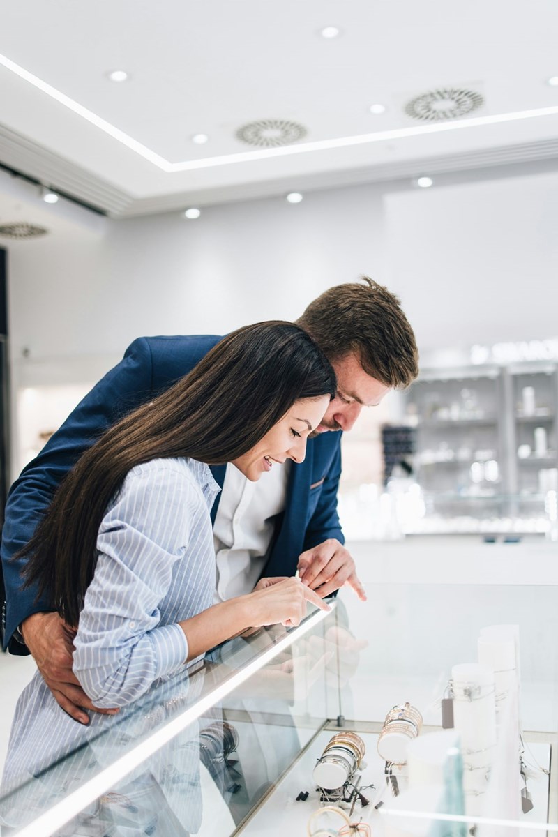 Couple seeing engagement rings in a jewelry store.