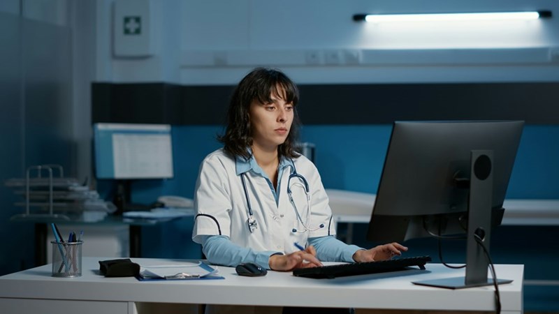 A hospital employee works late at a computer during a night shift.