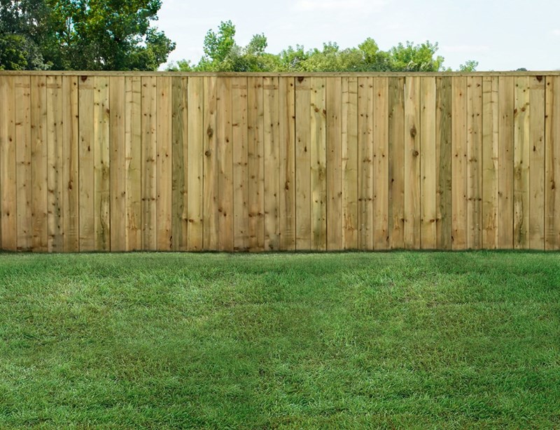 A wood fence dividing two backyards.