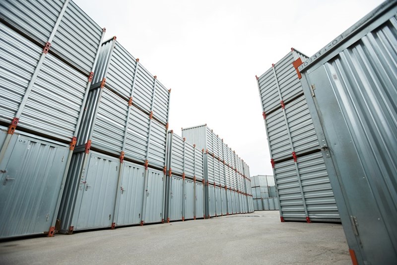 A depiction of an outside storage area with stacked shipping containers.