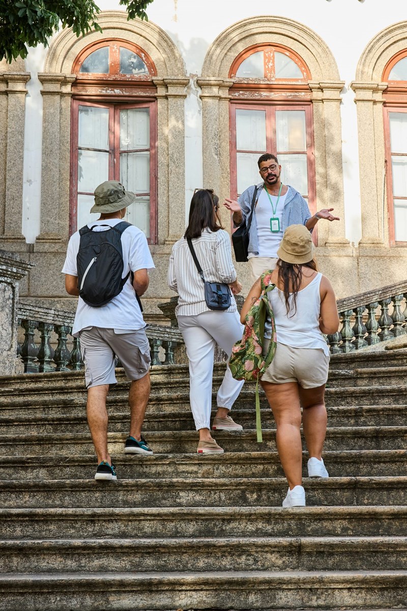 Tour group climbs stairs while listening to the guide give a speech.