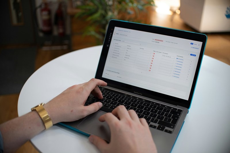 A pair of hands typing in a computer with a pending list on the screen.