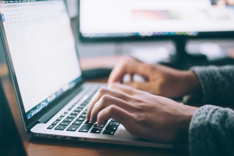 A man types, modeling his hands working on a laptop.