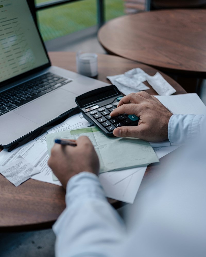 The representation of an employee crunching numbers to be able to afford his lifestyle on $50K less than he used to make.