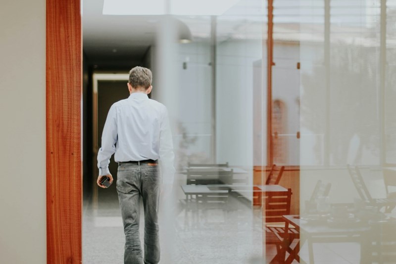 A model dressed in business attire leaves an office building.