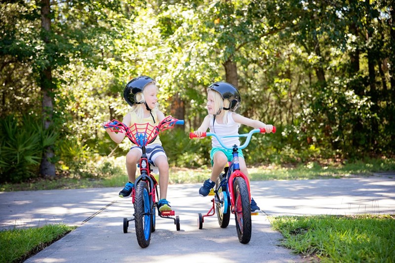 Two models riding bikes without any adults supervising them, in case a car drives by and isn't paying attention.