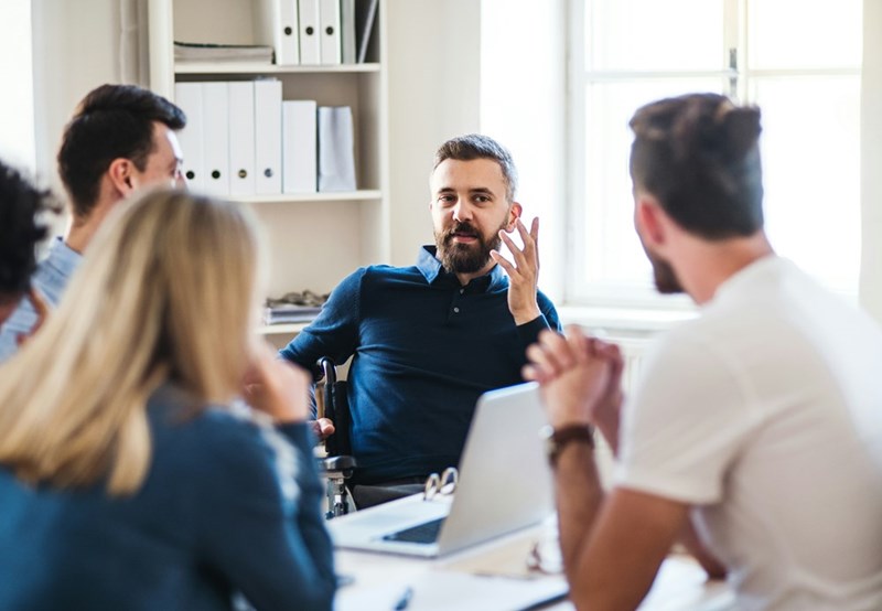 A worker tries to explain to his team why he has made critical mistakes on the job, as represented by models.