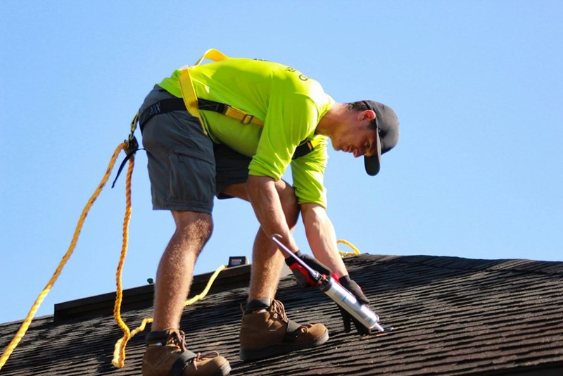 A close-up image of a model working on the roof of a suburban home.